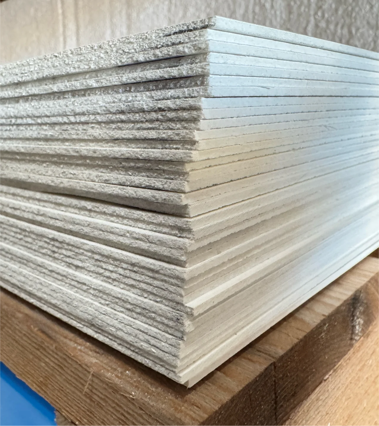 Pile de plaques fibrées lisses en stock chez ISOSELL pour faire des revêtements murs et plafonds lisse conformes aux normes HACCP